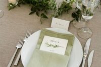 19 a chic wedding tablescape with a sage green napkin, a greenery runner and some candles