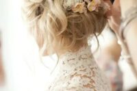 20 a messy and wavy wedding updo with small neutral flowers tucked in is a great idea for a spring boho bride