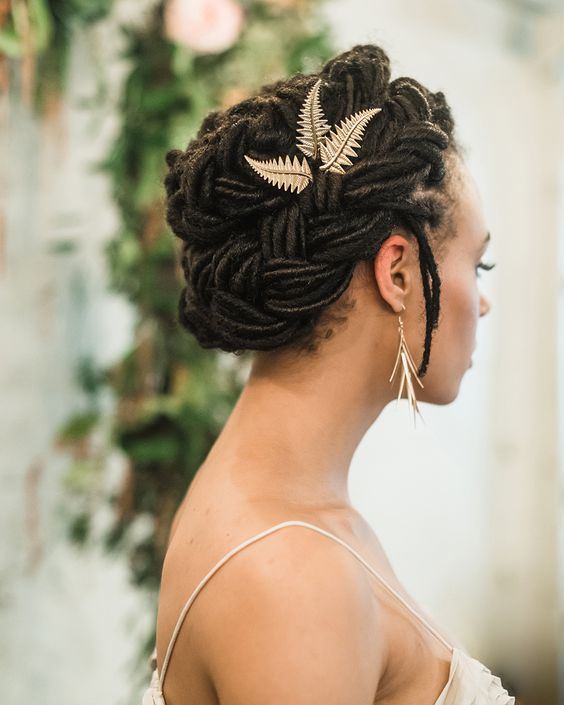 a gorgeous braided updo with some locks down and gold leaf hair pieces is a stylish idea for a boho bride