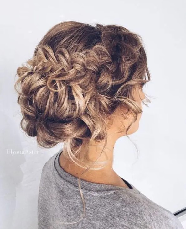 A low bun with a double braided halo and some curls down is a long lasting option to go for