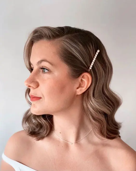 a stylish brown wavy bob with side parting and a pearl hair pin is a chic and cool wedding hairstyle to rock