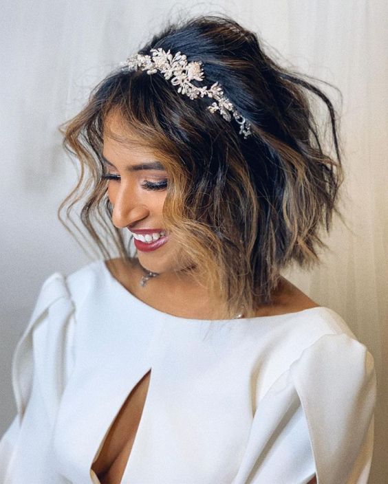a textured black bob with honey balayage and money piece and a floral headband is a cool and chic idea for a wedding