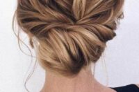 29 a messy twisted low bun with a messy top and some locks down is a stylish and chic idea for a not too formal bridal look
