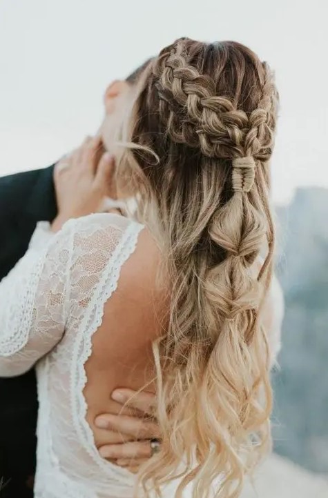 a gorgeous boho wedding half updo with a double braided halo, a bubble ponytail and waves down is amazing