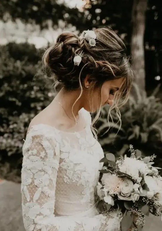 a messy twisted and braided updo with a braided halo and some curls down for a boho bride