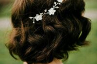 30 a wavy long dark brown bob with a bump on top and a delicate white floral hair vine is a very chic idea