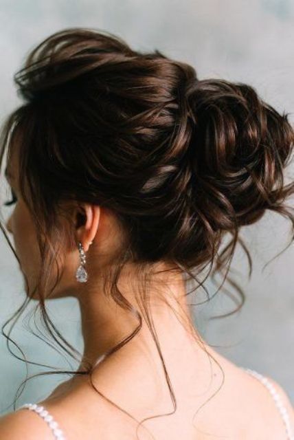 an elegant wavy wedding updo with a wavy top and a wavy bun, with some locks down is a chic and cool idea to rock