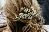 32 wavy textured hair with balayage and some fresh blooms tucked in is a cool and lovely solution for a wedding