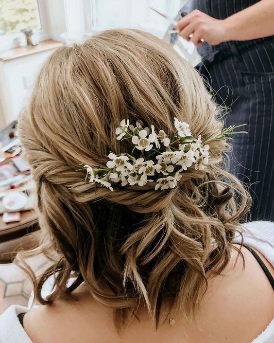 wavy textured hair with balayage and some fresh blooms tucked in is a cool and lovely solution for a wedding