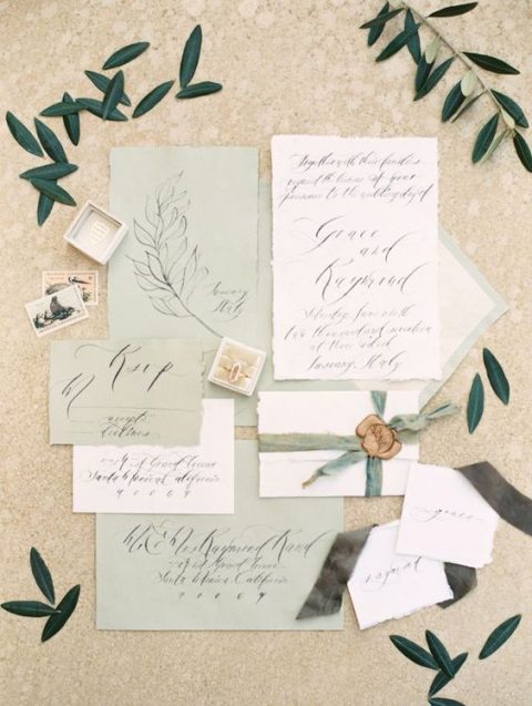 a romantic sage green wedding invitation suite with calligraphy and some botanical detailing