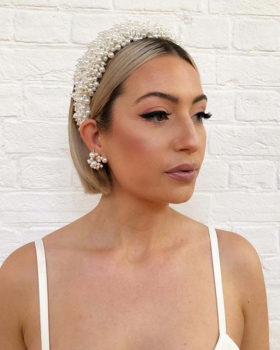 a cold blonde bob with a darker root and a large pearl headband plus matching earrings is a gorgeous idea for a wedding