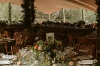 40 a welcoming fairy-tale wedding tablescape with a sage green tablecloth, bold blooms and greenery and gold-rimmed glasses