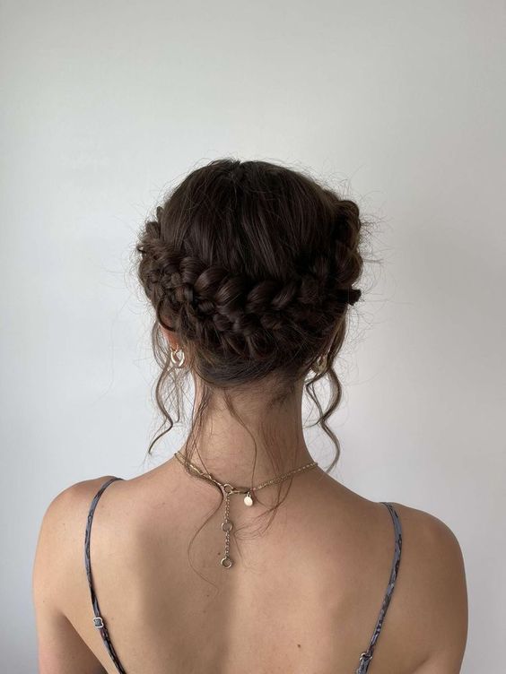 a beautiful and simple braided low updo with a halo and some locks down is a chic and cool idea for a wedding
