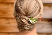 41 a beautiful and tight twisted low updo with a sleek top and a bit of fresh blooms is a cool and stylish idea for medium and long hair
