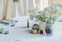 41 an airy wedding tablescape with a white tablecloth, sage green napkins, baby’s breath and succulents is modern and simple