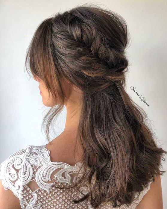 a lovely half updo with a large braided halo and a bump, waves down and some face-framing locks is amazing for a boho bride