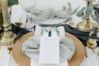 44 fresh eucalyptus arrangements in clear vases and a sage green napkin plus gilded touches for a fresh look