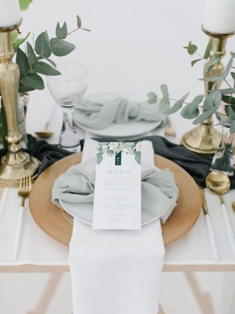 fresh eucalyptus arrangements in clear vases and a sage green napkin plus gilded touches for a fresh look