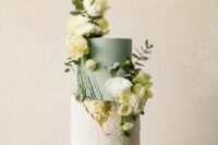 47 a catchy wedding cake with a textured white tier and a sage green one, gold leaf, white blooms and greenery