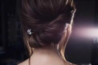 47 a chic twisted low chignon with some bangs down and a little rhinestone hairpiece for a modern bride