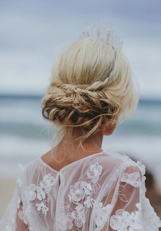 a cool low updo with a fishtail and twisted braid, some locks down and a crystal crown are a great combo for a beach bride