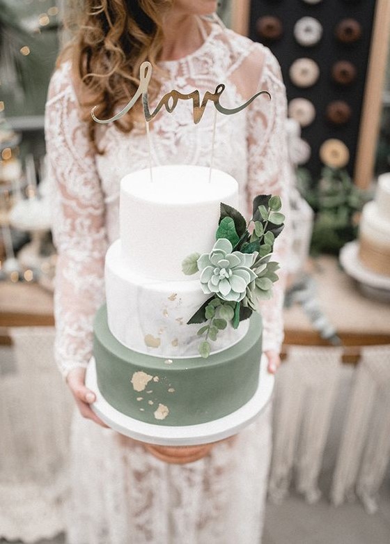 a chic modern green and white wedding cake with a marble tier, greenery and succculents, gold leaf and a calligraphy topper