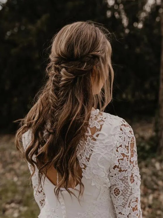 a cool boho half updo with a double braided halo and a fishtail braid and waves down is a cool idea for a boho bride