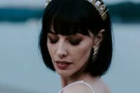 48 a stylish black bob with fringe and a gold and crystal crown plus matching gold earrings for a bold modern bridal look