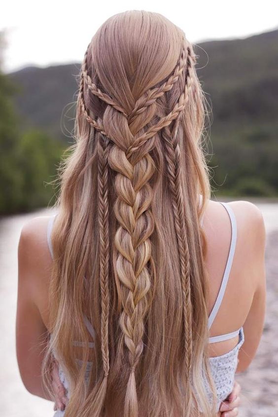 a braided half updo with several small and large braids down and long hair down is a chic and cool idea for a boho bride
