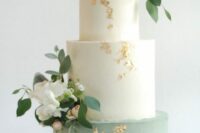 49 a chic wedding cake with white and sage green tiers and fresh blush and white blooms plus gold leaf