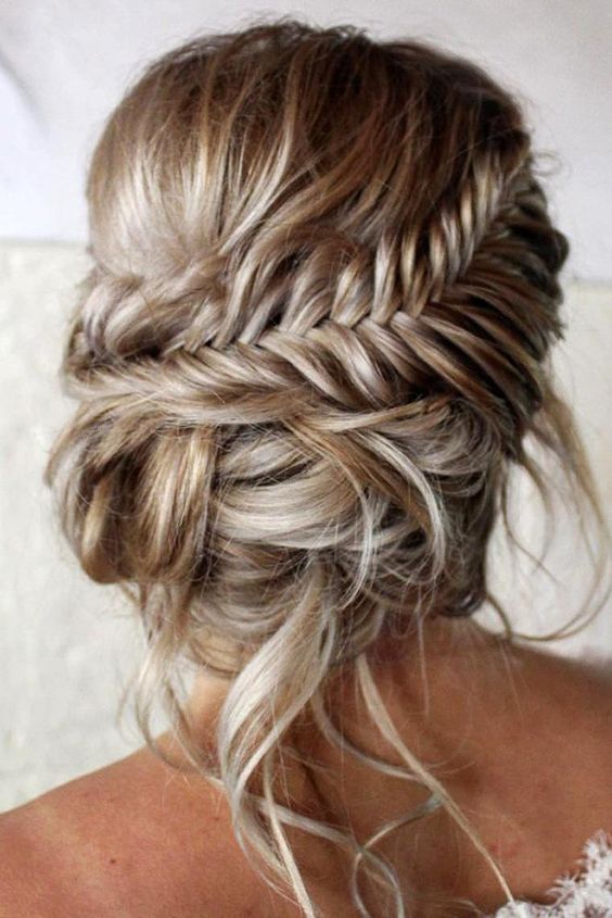a messy fishtail braid updo with curls and waves and a bump on top is a cool and chic idea to try right now