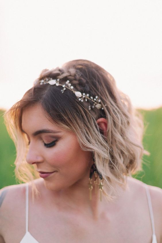 a wavy and textured blonde bob with a darker root and a delicate hair vine is a very chic and cool solution for a wedding