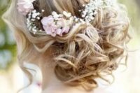 50 a wavy low updo with locks down and some fresh blooms tucked into the hair is a romantic idea for a boho chic bride