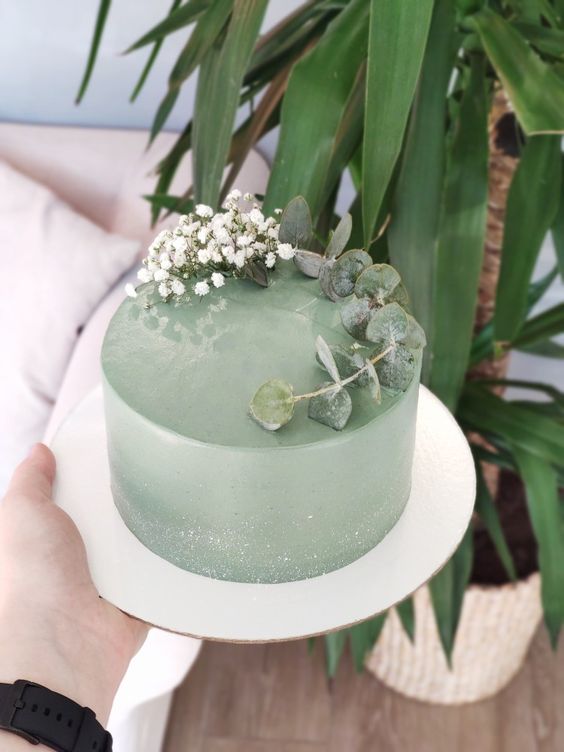 a lovely sage green wedding cake topped with eucalyptus and baby's breath is a cool idea for a modern wedding