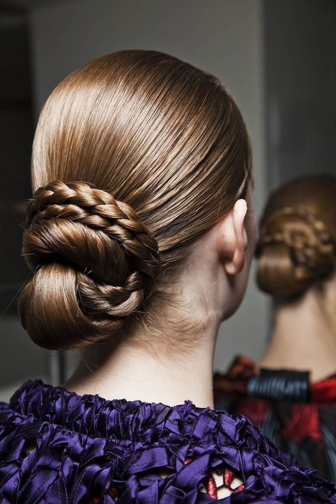 a modern updo with a braid and twists plus sleek and shiny hair is a cool idea for a modern or minimalist bride