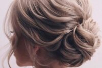 55 an elegant wavy wedding updo with a chignon and a wavy volume on top, with some locks down is chic