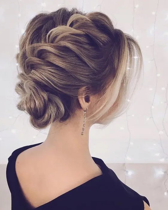 a voluminous braided updo with some locks around the face looks super elegant