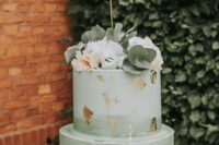 56 an ombre sage green wedding cake with gold leaf, neutral blooms and eucalyptus and a calligraphy topper