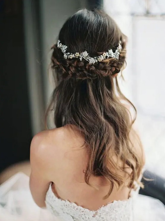 a beautiful half up hairstyle with a thick braided halo and a chic rhinestone floral hair vine is a lovely idea