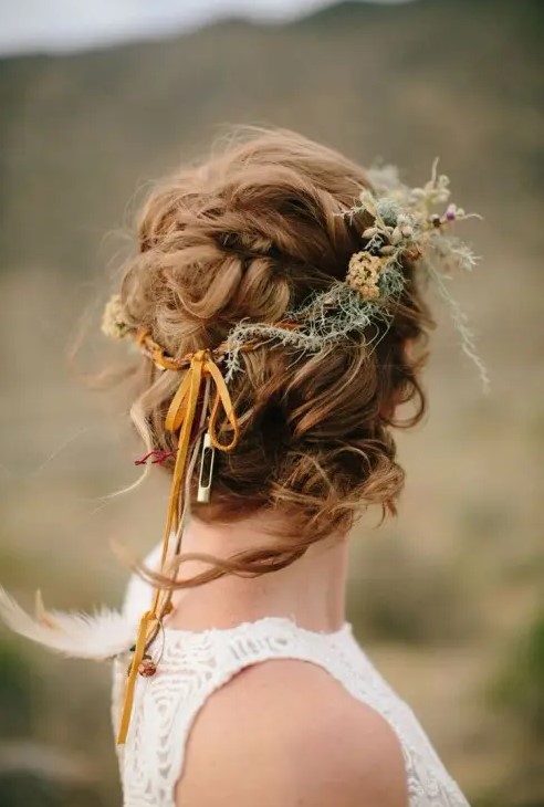 a messy and twisted updo with a volume on top and some locks down and a dried flower crown is a great solution for a fall boho bride
