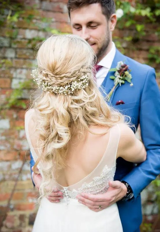 a braided half updo with a double halo and with baby's breath looks sweet and will fit a rustic wedding