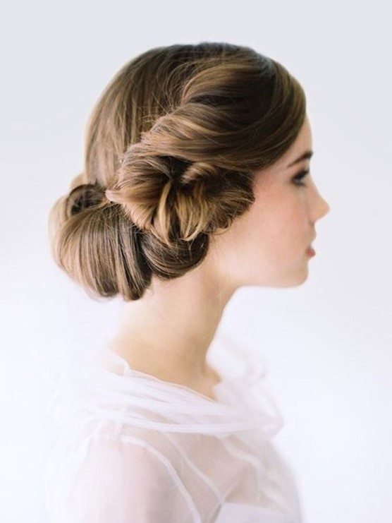 a unique wedding hairstyle with a twisted lower part and a sleek top is a fresh take on a vintage hairstyle