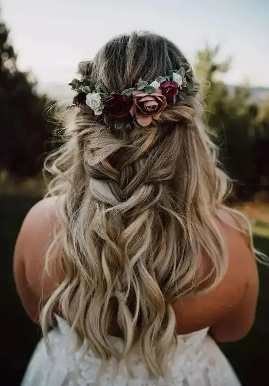 a lovely and classy half updo with a twisted halo and a loose braid and a bold fall flower crown is amazing