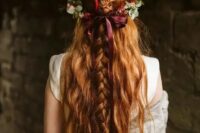 75 a pretty half updo with messy and textural braids on top and wavy locks down plus a greenery and fall floral crown with a burgundy bow