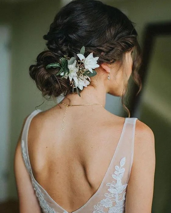 a refined wedding low bun with twists and a braid, with white blooms will match a fall and a summer wedding