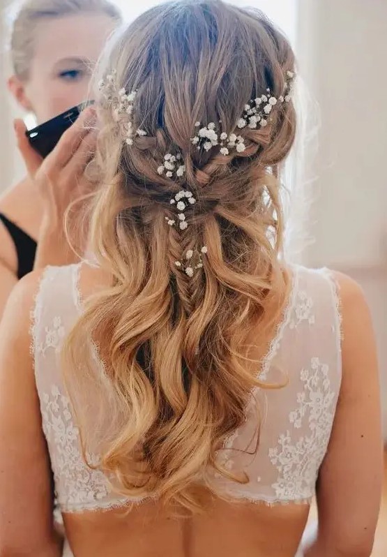 a twisted braided half updo with waves and baby's breath tucked in