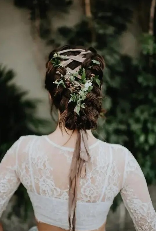 A unique braided low updo with a blush ribbon and fresh greenery interwoven looks very eye catchy and boho