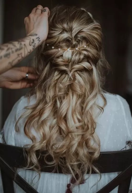 a wavy twisted half updo with a messy top, a pearl headband and waves down is a chic and romantic idea