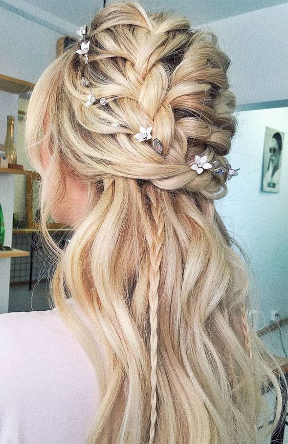 a wedding half updo with a braided top, waves down and small braids down plus face-framing locks for a boho bride