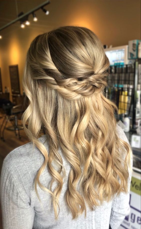 a blonde bridal half updo with a bump on top and a double twisted halo plus some waves down is a cool and lovely idea for a boho or rustic bride